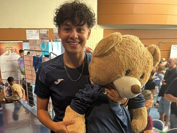 Boubou, la mascotte en tenue du CoPing, dans les bras d'un membre du club