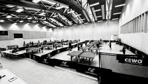 Vue d'ensemble de la salle du stage, les tables align&eacute;es et les jeunes &agrave; l'&eacute;chauffement